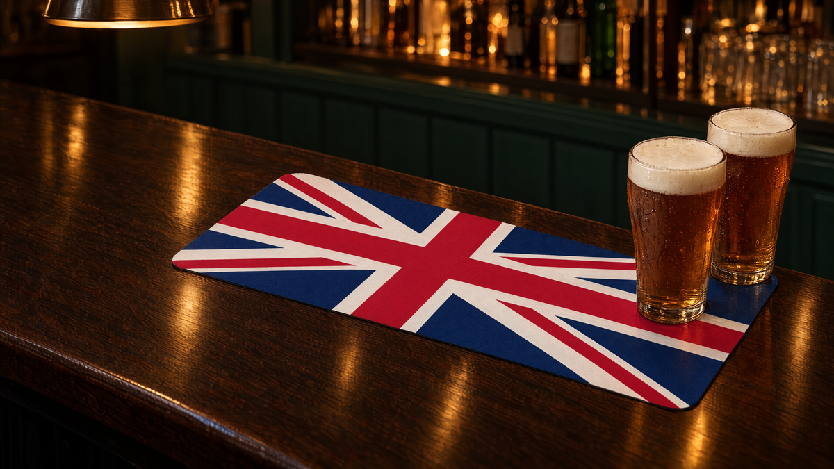 Two pints of ale on a Union Jack rubber bar runner mat on a dark wooden home bar
