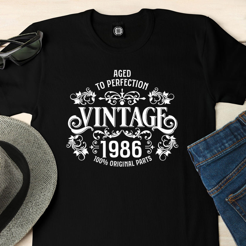 Close-up of the Vintage 1986 Aged to Perfection print on a black 40th birthday t-shirt