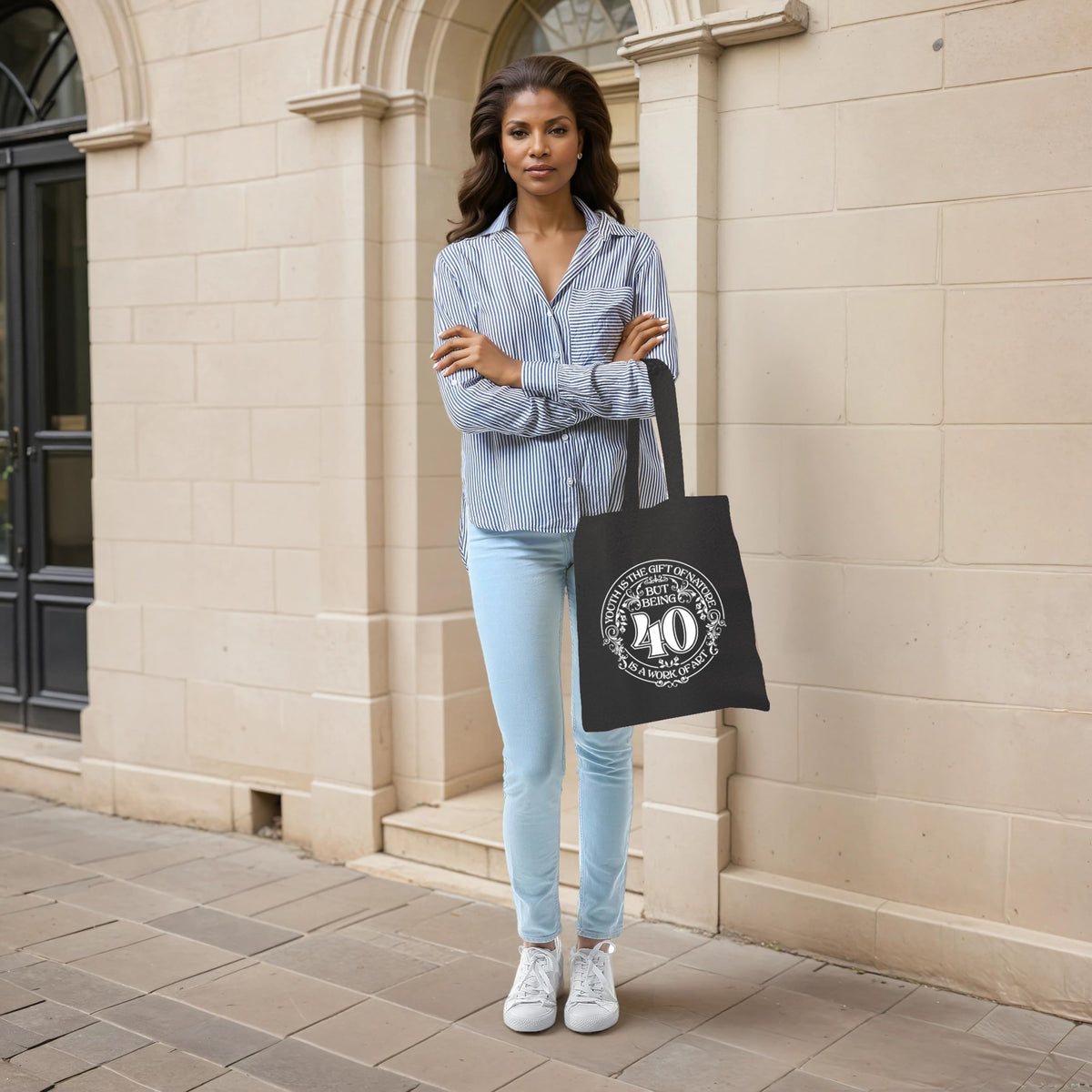 Woman holding the Being 40 is a Work of Art 40th birthday tote bag in black