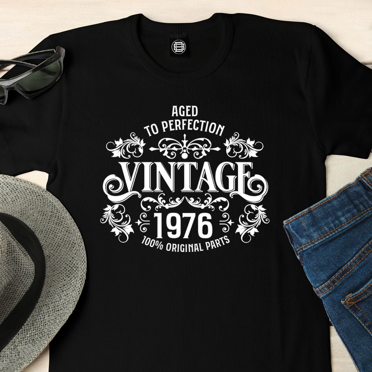 Close-up of the Vintage 1976 Aged to Perfection print on a black 50th birthday t-shirt