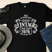 Close-up of the Vintage 1976 Aged to Perfection print on a black 50th birthday t-shirt