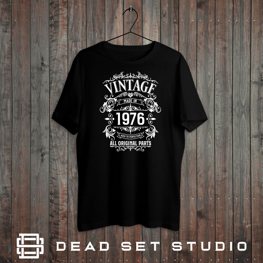 Vintage 1976 All Original Parts 50th birthday t-shirt in black on a rustic wood background
