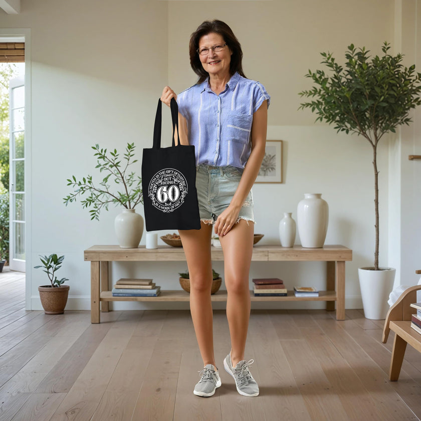 Woman carrying the black Being 60 is a Work of Art 60th birthday tote bag
