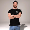 Man wearing the black Loyal to the Grave skull t-shirt, front view with arms crossed