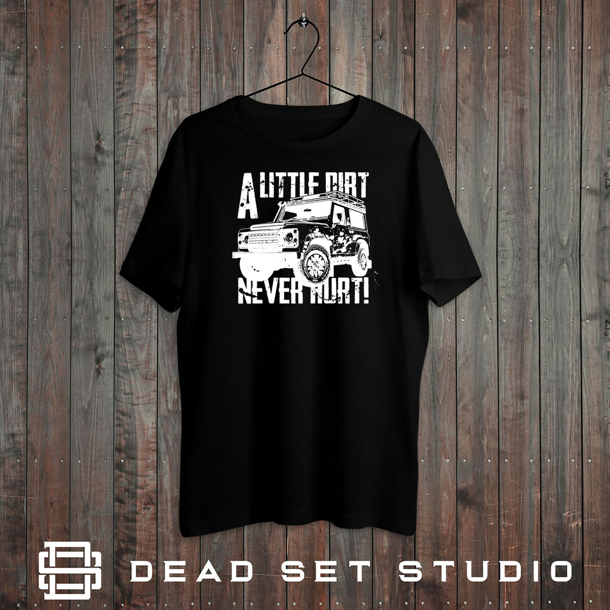 A Little Dirt Never Hurt off road 4x4 t-shirt in black on a rustic wood background